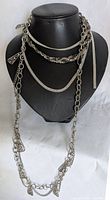 Photo showing all 3 necklaces displayed on a black bust showcasing braided, flat, and chain styles with pendant charms.