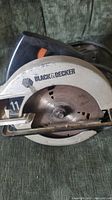 Top view of Black & Decker circular saw showing the blade and brand logo, with visible signs of wear and rust on blade.