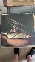 Vinyl album 'Killing Me Softly' by Roberta Flack with cover showing minor wear.