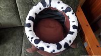 Top-down view of circular plush cat bed showing spotted white outer rim and brown cushioned interior.