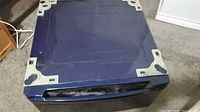 Top view of the blue washing machine or dryer pedestal showing the flat top and inset area for placing appliance.