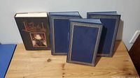 Four hardcover books with blue covers and gold border design, one book titled Elizabeth I hardcover edition