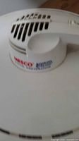 Top view showing the vented lid with Nesco branding and handle on white plastic dehydrator.