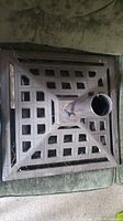 Top-down view showing square lattice cast iron base and central umbrella pole holder with tightening screw.