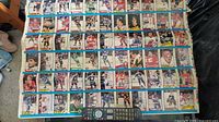 Full view of the hockey trading card sheet showing multiple cards with player images and team logos, placed next to a remote for scale.