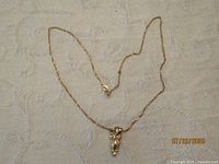 Full view of owl pendant necklace laid flat