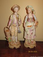 Pair of ceramic Victorian couple figurines on table