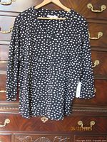 Front view black flecked dot Chico's top on hanger