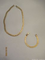 Gold-tone flat-link necklace and matching bracelet laid out