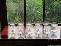 Front view of all 11 crystal coupe glasses on windowsill