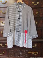 Front view showing mixed fabrics, toggle closures, collar, red accent