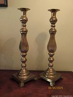 Front view of both brass candlestick holders showing height and design