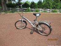 Full left-side view of silver folding bicycle with rack and fenders
