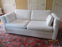 Front view of off-white convertible sofa with cushions