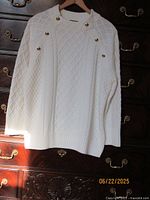 Front view of Talbots white cable-knit sweater with gold-tone buttons