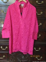 Front view of hot pink lace blouse hanging