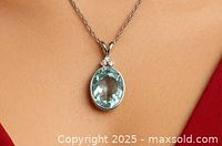 Aquamarine and diamond pendant worn on a chain showing scale and appearance when worn.