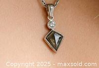 Pendant hanging on chain showing overall design including brown diamond and white diamond accent