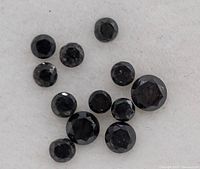 Close-up of round faceted black diamonds showing detail and texture.