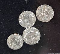 Four loose diamonds on black background