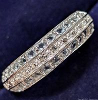 Close-up view of silver ring with multiple aquamarine stones arranged in three rows, highlighting the stone settings and silver band.