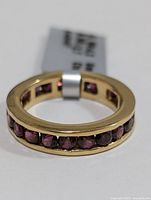 Close-up front view of the silver garnet ring showing garnet stones in a channel setting around the band.