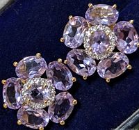 Front view showing floral design of faceted oval light purple amethyst stones held by gold-tone prongs.