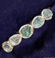 Top view of sterling silver ring with five rough-cut blue diamonds in a line.