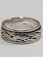Front angle view of silver ring showing woven pattern and polished finish.