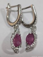 Front view of sterling silver drop earrings showing ruby and cubic zirconia stones.