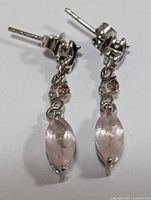 Front angled view of the pair of silver earrings showing the dangle design with marquise-cut rose quartz stones and small round pink stones, butterfly post backs.