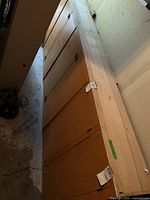 Long side view of the wooden cabinet showing the full length with multiple cupboard doors.