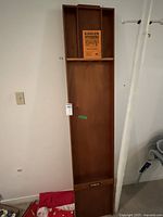 Full view of the long wooden shuffleboard (Sjoelbak) table showing its length and structure with the Homas brand plaque and worn finish.