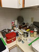 Overview of kitchen items on countertop including vintage Terraillon scale, various utensils, hand blenders, and stainless steel bowls.