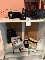 Full lot display showing Motorola radios on right and additional radios on left, cameras and binoculars below.