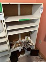 Full view of white wooden shelf unit with multiple shelves, showing age and wear. Note contents are excluded from lot.