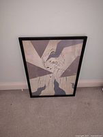 Framed wall art featuring a stylized black and white 1980s style portrait print with geometric shapes in a black frame.