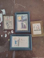 Lot of four framed antique postcards shown together revealing detailed artwork and text.