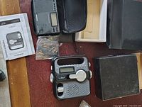Photo showing LL Bean portable radio with its manual, box, and accessories including a plastic bag possibly with batteries or connectors.