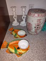 Photo showing the ceramic garden stool, white candle holders, and koi fish bowls on a countertop