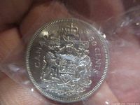 Reverse side of the 1969 Canadian 50 cent coin showing the Canadian Coat of Arms and denomination.