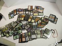 Large assortment of Magic: The Gathering cards spread out, showing various cards and colors.