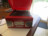 Red TEAC stereo record and radio player unit, closed lid, showing front speaker grills and controls