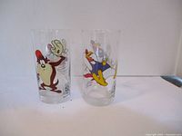 Front view of two collectible glasses featuring Tasmanian Devil and Daffy Duck Looney Tunes characters