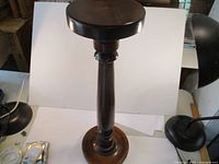 Angle side view of the entire plant stand capturing the smooth finish and shape of the turned wooden column.