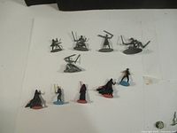 Top view of all pewter and plastic Star Wars monopoly pieces arranged on a white background.