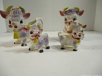 Four vintage Elsie the Cow ceramic pieces showing front view with cream, sugar, salt, and pepper set.
