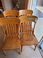 Four wooden chairs grouped together showing natural wood finish and vertical slat backs.