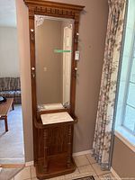 Full view of the wooden hall tree showing mirror, marble tray, and umbrella holder base.