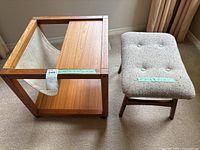 Teak magazine rack and wooden stool side by side on carpet